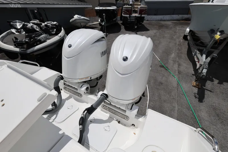 Slide: The Image of 2024 Sea Hunt Gamefish 25 with dual Yamaha outboard motors in a boatyard setting. - 22