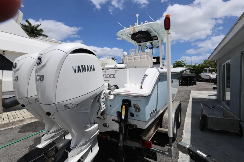 Slide: The Image of 2024 Sea Hunt Gamefish 25 with dual Yamaha engines, parked outdoors under a blue sky. - 5