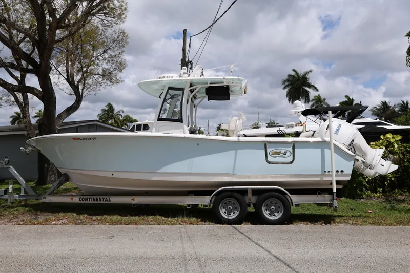 Slide: The Image of 2024 Sea Hunt Gamefish 25 boat on trailer, parked outdoors under cloudy sky. - 7