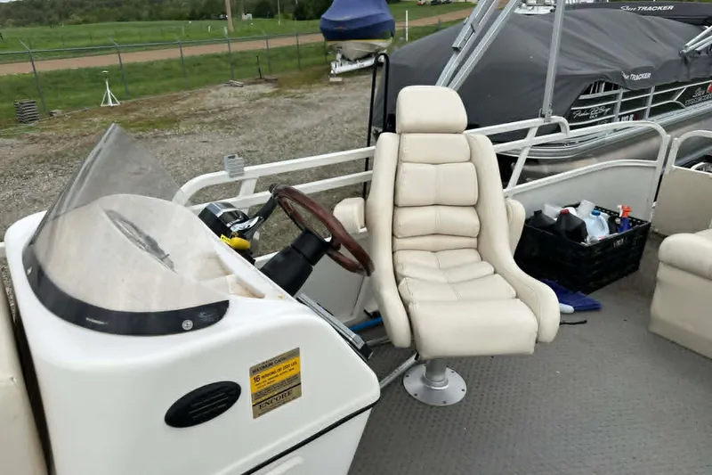 Slide: The Image of 2011 Bentley Pontoons 250/253 Elite Admiral helm with beige captain's chair and steering wheel. - 12