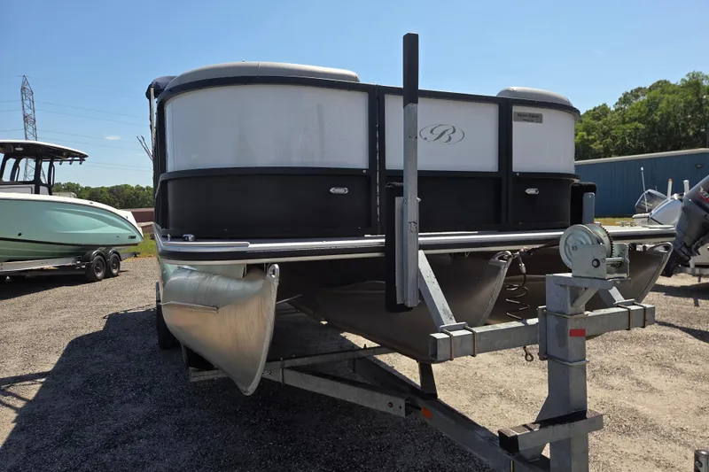 Slide: The Image of 2022 Bentley Pontoons 240 Navigator on trailer, parked outdoors under clear sky. - 2