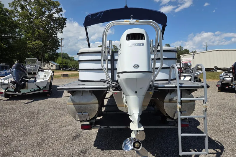 Slide: The Image of 2022 Bentley Pontoons 240 Navigator with outboard motor, parked outdoors under a clear sky. - 5