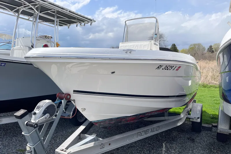 The Image of 2018 Robalo R180 Center Console boat on trailer, parked outdoors under cloudy sky. - 0