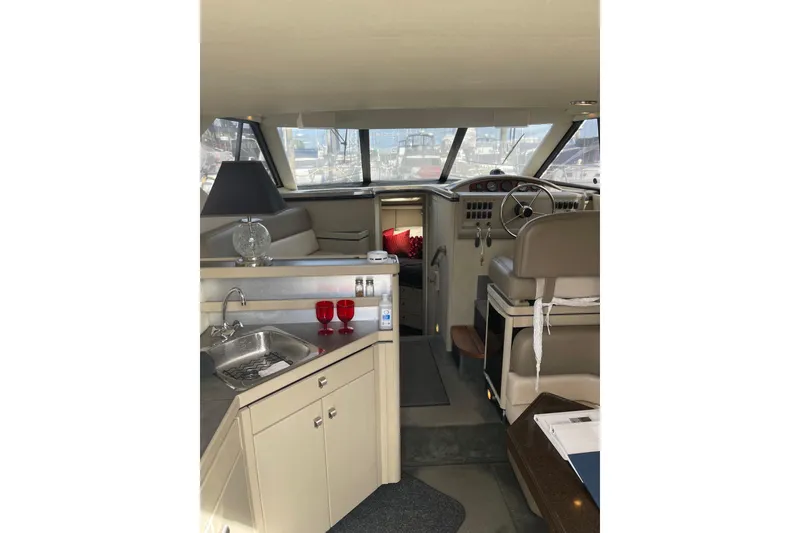 Slide: The Image of Interior of 1996 Bayliner 3255 Avanti boat with helm, seating, and kitchenette. - 12