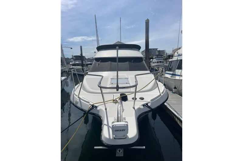 Slide: The Image of 1996 Bayliner 3255 Avanti docked at marina, front view with clear sky. - 2