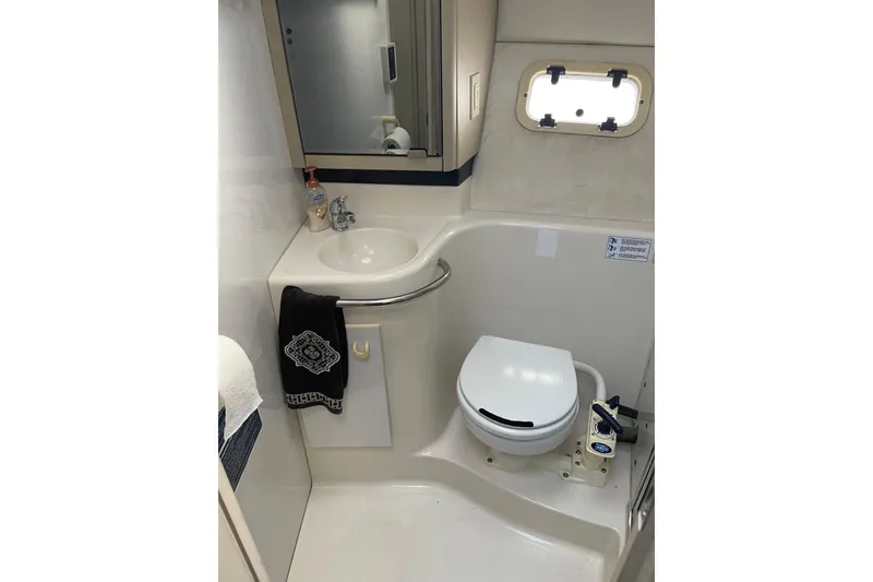 Slide: The Image of 1996 Bayliner 3255 Avanti boat bathroom with sink, mirror, and toilet. - 24