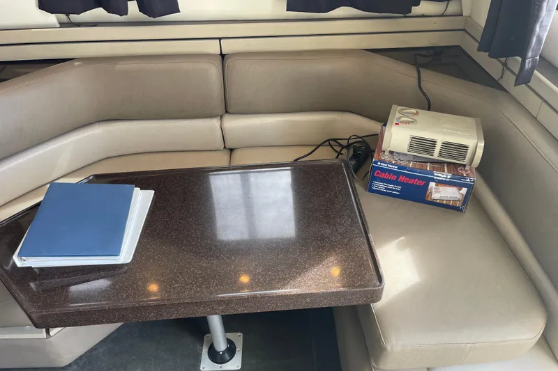 Slide: The Image of 1996 Bayliner 3255 Avanti cabin interior with table, binder, and cabin heater. - 29