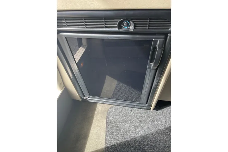 Slide: The Image of 1996 Bayliner 3255 Avanti cabin refrigerator with black door and control knob. - 30