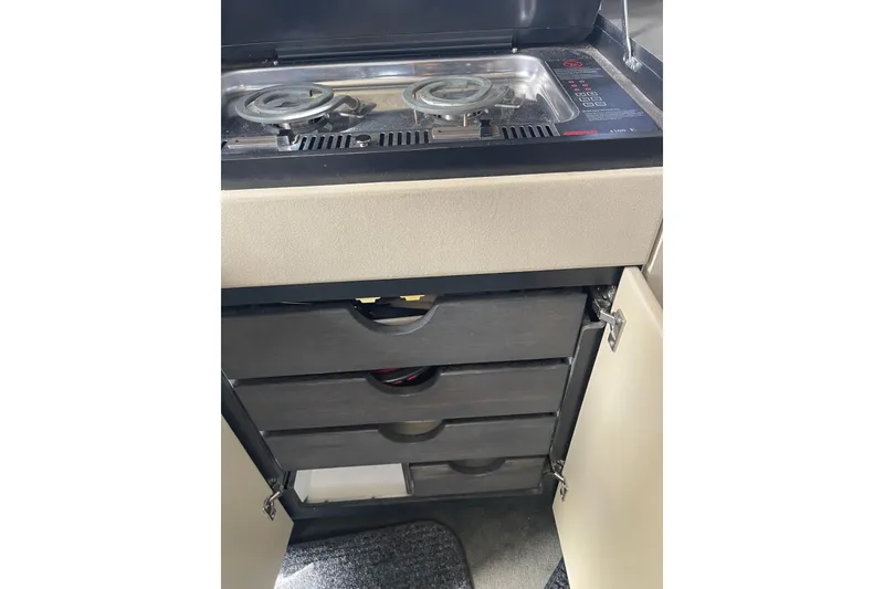 Slide: The Image of 1996 Bayliner 3255 Avanti kitchen with stove and storage drawers. - 33