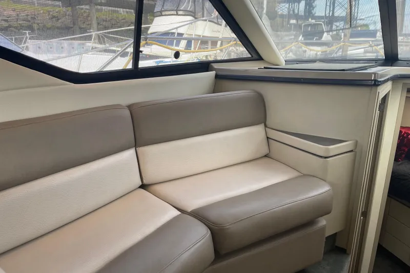 Slide: The Image of Interior of a 1996 Bayliner 3255 Avanti boat with beige seating and window view. - 35