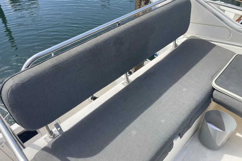 Slide: The Image of Gray seating area on a 1996 Bayliner 3255 Avanti boat, docked by the water. - 8