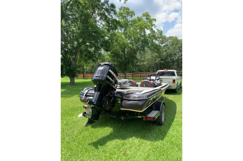 Slide: The Image of 2010 Nitro Z-7 boat with Mercury engine on grassy lawn, parked near a white truck. - 3