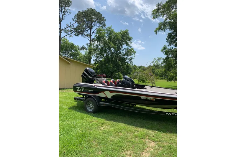 Slide: The Image of 2010 Nitro Z-7 boat on trailer, parked on grass, surrounded by trees and clear sky. - 4