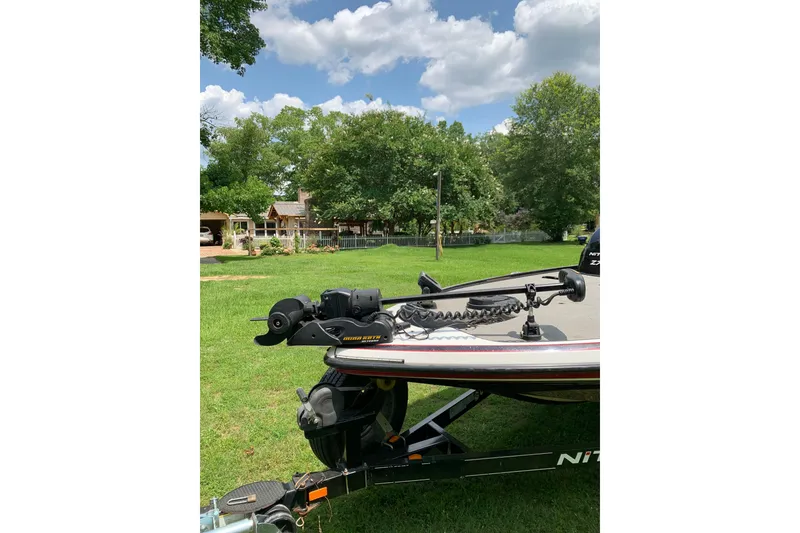 Slide: The Image of 2010 Nitro Z-7 boat on trailer, parked on grassy lawn with trees and cloudy sky. - 5