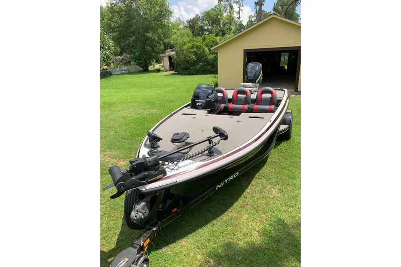 Slide: The Image of 2010 Nitro Z-7 boat on grass, near a garage, with motor and seating. - 6