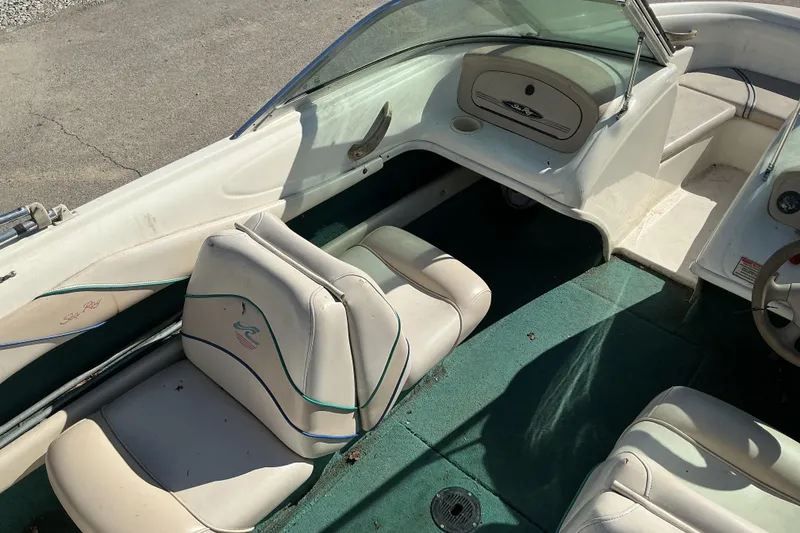 Slide: The Image of 1998 Sea Ray 175 Bow Rider interior with white seats and green carpet. - 8