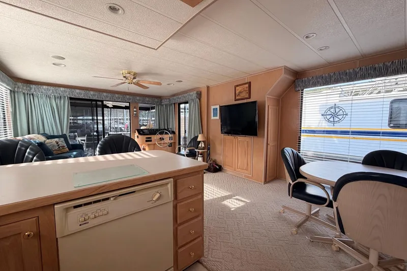 Slide: The Image of Spacious Sunstar 16x65 houseboat interior with kitchen, dining area, and living space, year 2000 model. - 13