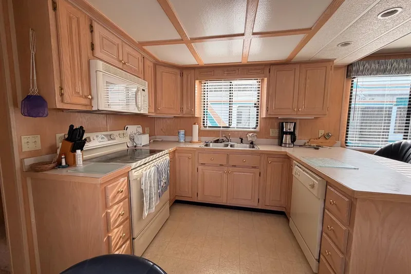 Slide: The Image of Spacious kitchen in a 2000 Sunstar 16x65 houseboat with wooden cabinets and modern appliances. - 14