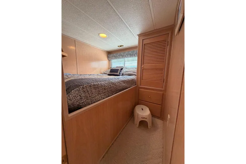 Slide: The Image of Cozy bedroom interior in 2000 Sunstar 16x65 houseboat with wooden cabinetry and soft lighting. - 16