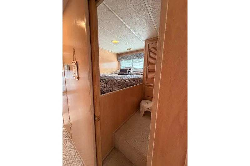 Slide: The Image of Cozy bedroom interior in 2000 Sunstar 16x65 houseboat with wooden paneling and bed. - 17
