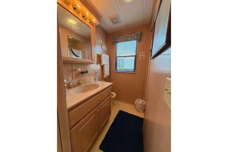Slide: The Image of Bathroom in 2000 Sunstar 16x65 houseboat with wooden cabinetry and vanity mirror. - 19