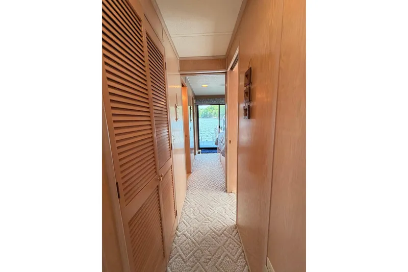Slide: The Image of Hallway inside 2000 Sunstar 16x65 houseboat with wooden paneling and carpet flooring. - 21