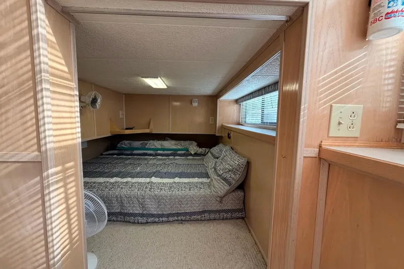 Slide: The Image of Cozy bedroom in 2000 Sunstar 16x65 houseboat with wood paneling and natural light. - 23