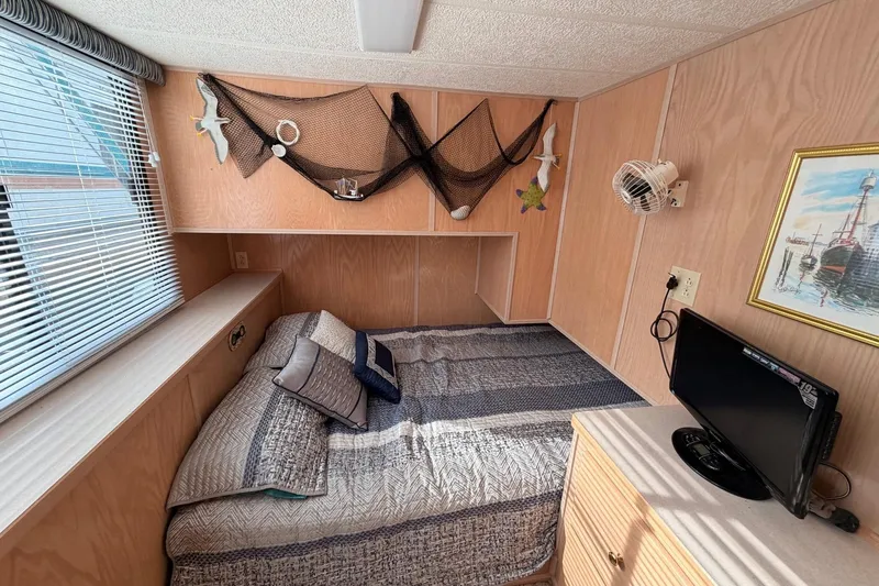 Slide: The Image of Cozy bedroom in 2000 Sunstar 16x65 houseboat with nautical decor and small TV. - 25