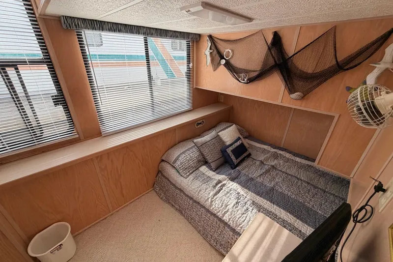 Slide: The Image of Cozy bedroom in 2000 Sunstar 16x65 houseboat with nautical decor and striped bedding. - 26