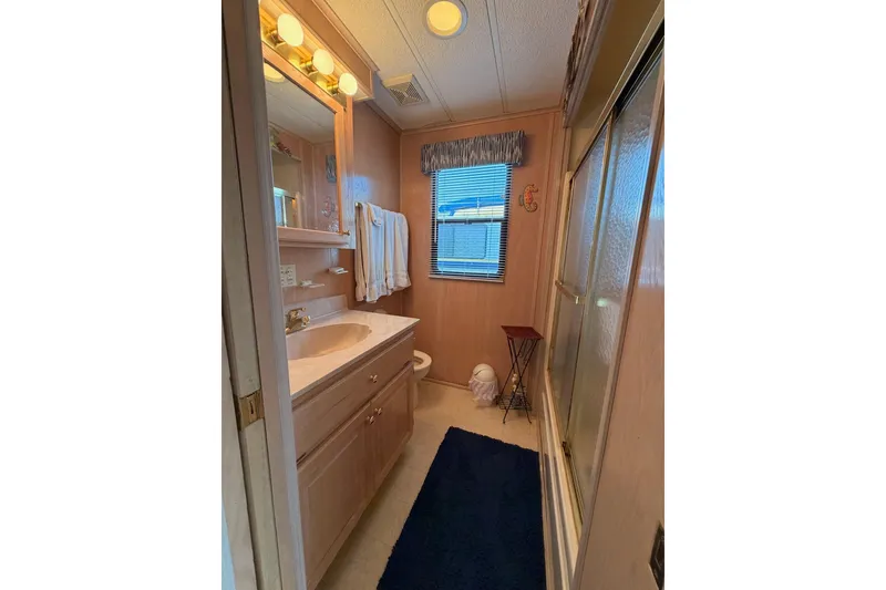 Slide: The Image of Compact bathroom in a 2000 Sunstar 16x65 houseboat with shower and vanity. - 29