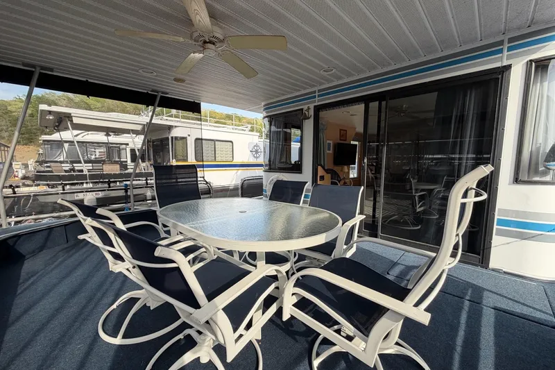 Slide: The Image of Outdoor seating area on a 2000 Sunstar 16x65 houseboat with glass table and chairs. - 3