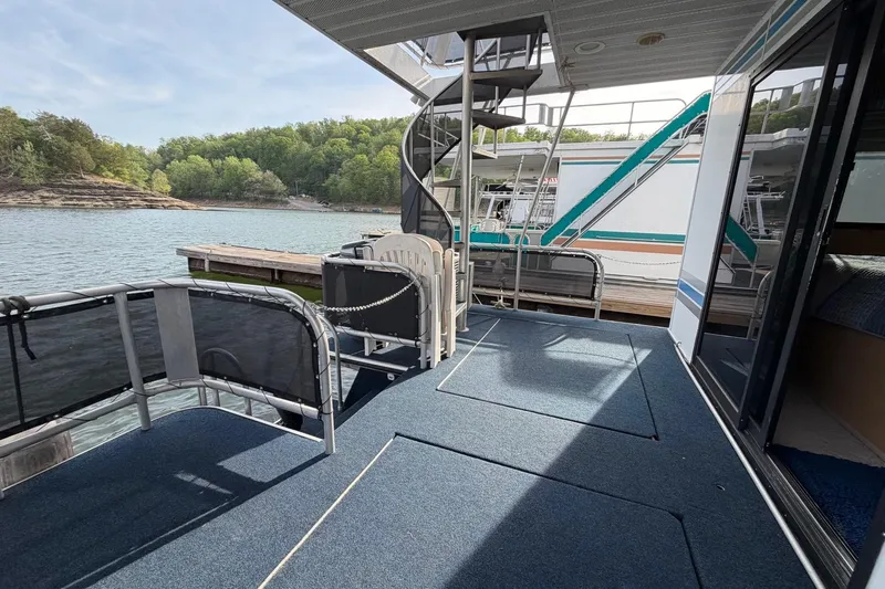 Slide: The Image of Sunstar 16x65 houseboat deck with spiral staircase, docked by a scenic lake. - 34