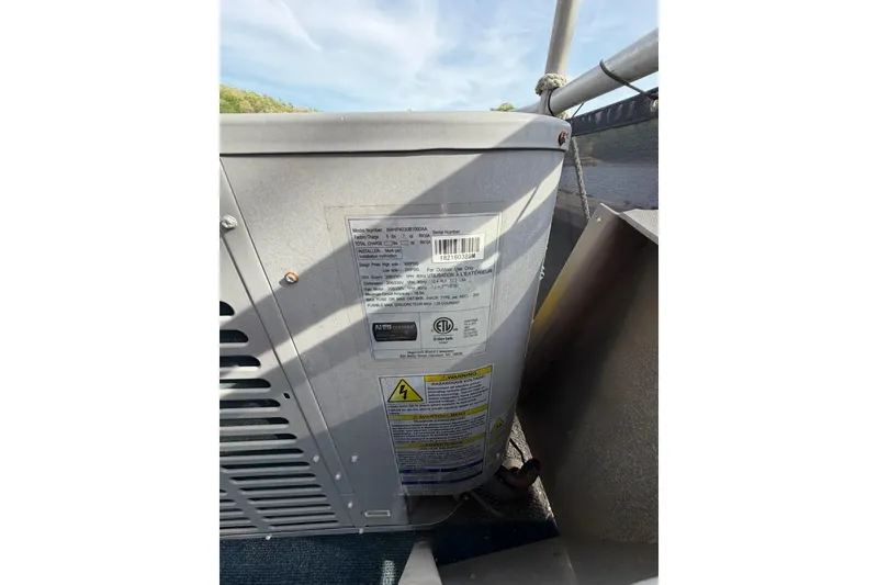 Slide: The Image of Outdoor HVAC unit with warning labels, Sunstar 16x65, 2000 model, under a clear sky. - 37