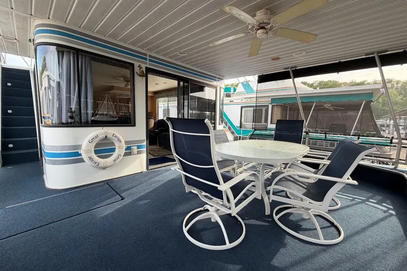 Slide: The Image of Spacious deck of 2000 Sunstar 16x65 houseboat with outdoor seating and ceiling fan. - 4
