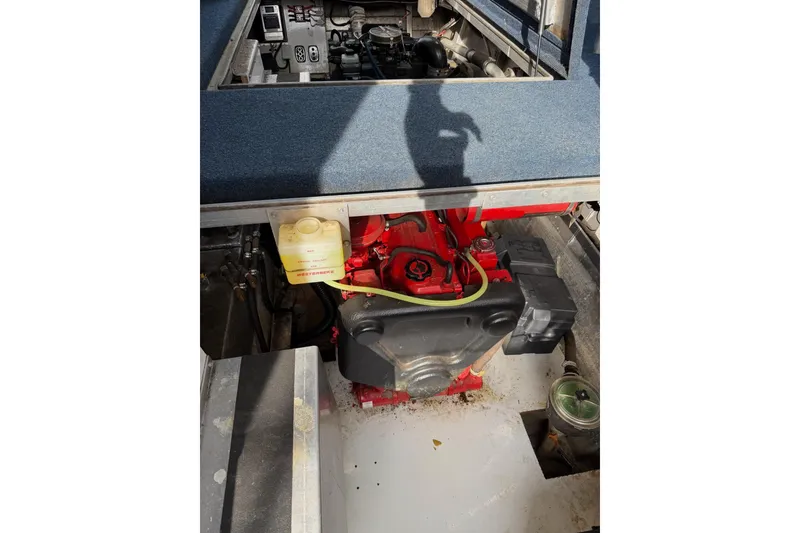 Slide: The Image of Engine compartment of a 2000 Sunstar 16x65 houseboat, featuring a red engine and components. - 41
