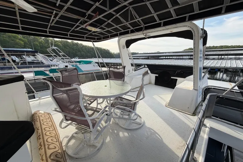 Slide: The Image of Outdoor seating area on a 2000 Sunstar 16x65 houseboat, docked at a marina. - 44