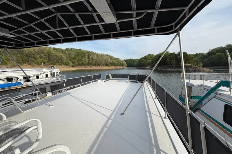 Slide: The Image of Upper deck of a 2000 Sunstar 16x65 houseboat overlooking a serene lake and forest. - 47