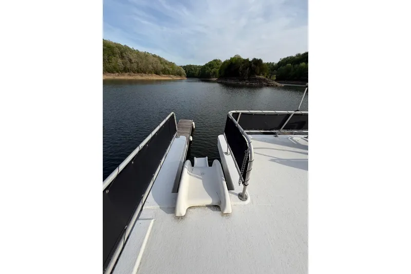 Slide: The Image of Sunstar 16x65 houseboat deck with slide, overlooking serene lake and lush shoreline. - 49