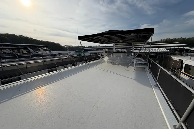 Slide: The Image of Sunstar 16x65 houseboat deck, 2000 model, docked under a clear sky. - 50