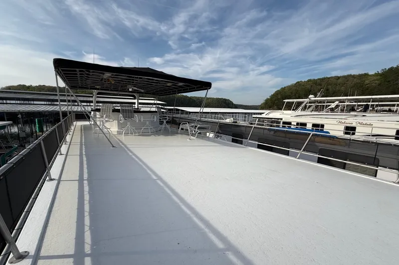 Slide: The Image of Sunstar 16x65 houseboat deck with canopy, chairs, and scenic marina view. - 52