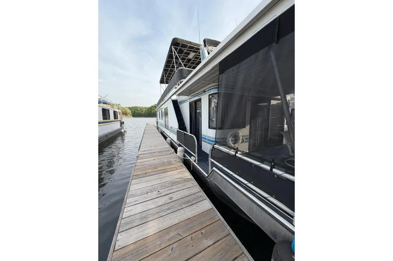 Slide: The Image of Houseboat docked on a lake, Sunstar 16x65 model, year 2000, with wooden walkway. - 54