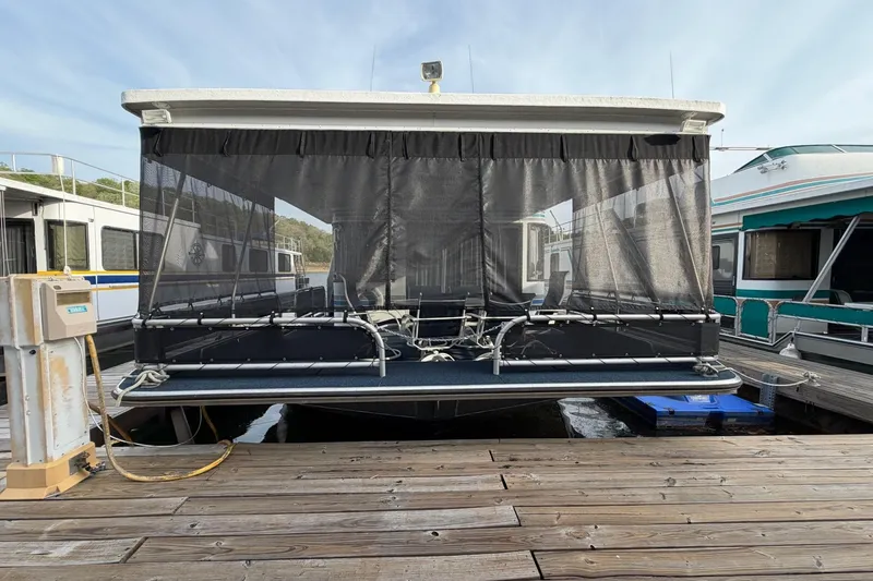 Slide: The Image of Front view of a 2000 Sunstar 16x65 houseboat docked at a marina. - 55
