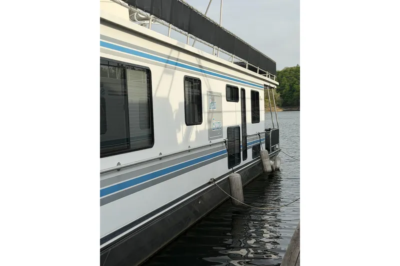 Slide: The Image of Sunstar 16x65 houseboat from 2000 docked on a calm lake. - 57