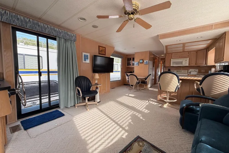 Slide: The Image of Interior of a 2000 Sunstar 16x65 houseboat with cozy living area and kitchen. - 7