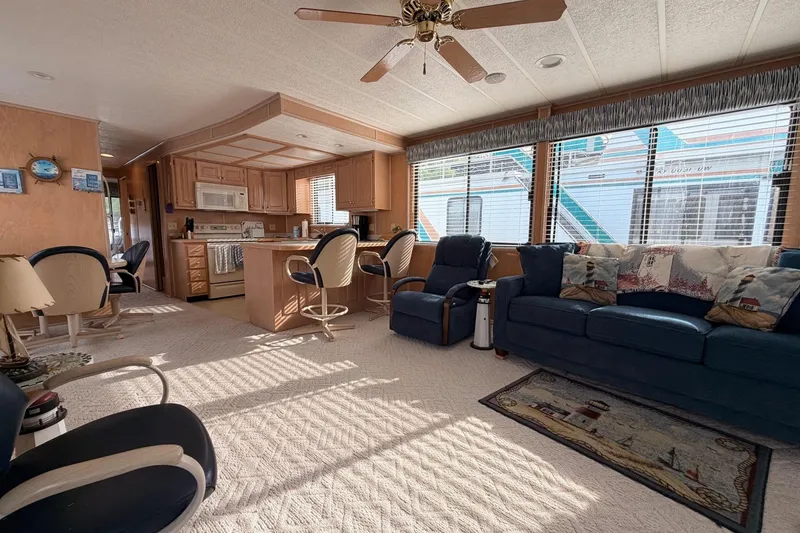 Slide: The Image of Spacious Sunstar 16x65 houseboat interior with kitchen, seating area, and large windows, year 2000. - 8