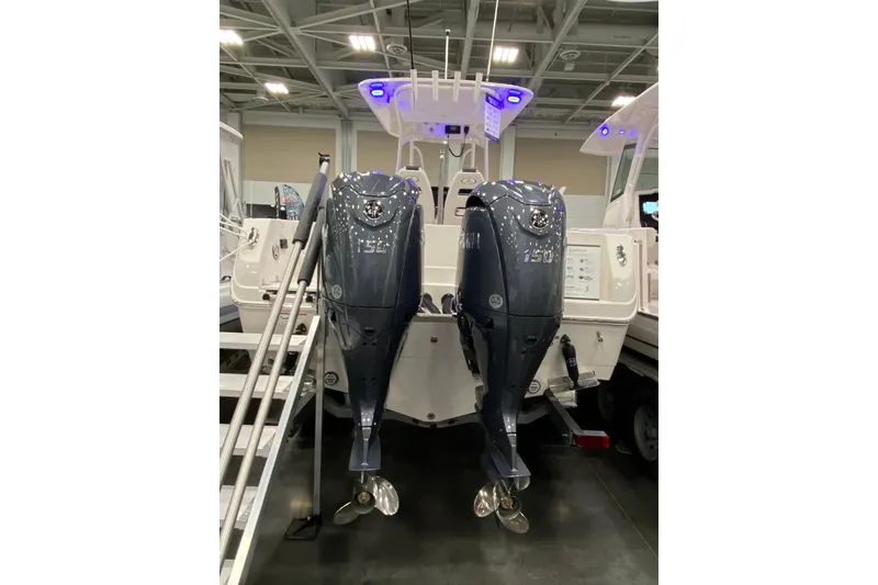 Slide: The Image of 2024 Sailfish 242 CC boat with dual outboard motors displayed indoors. - 10