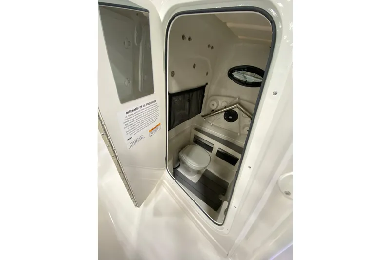 Slide: The Image of 2024 Sailfish 242 CC boat interior with compact marine toilet and storage. - 16