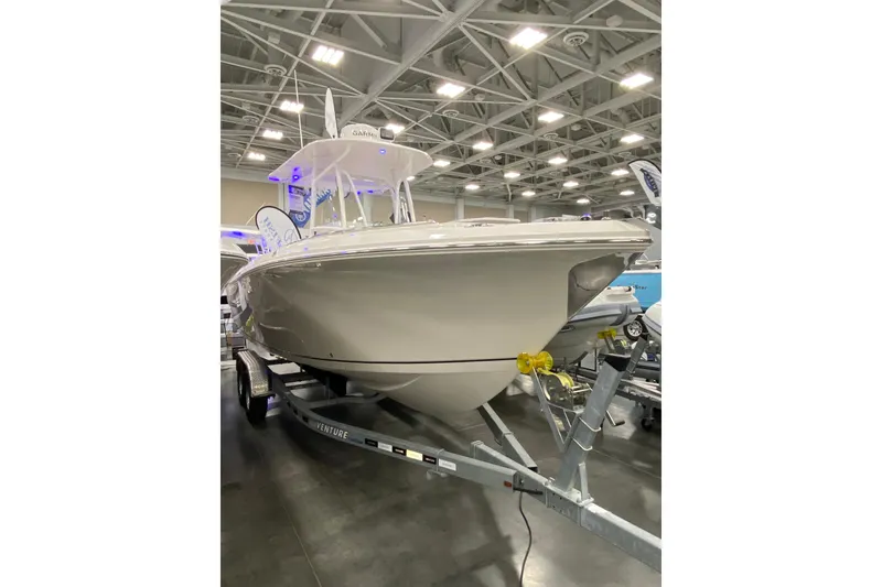 Slide: The Image of 2024 Sailfish 242 CC boat displayed indoors on a trailer. - 8