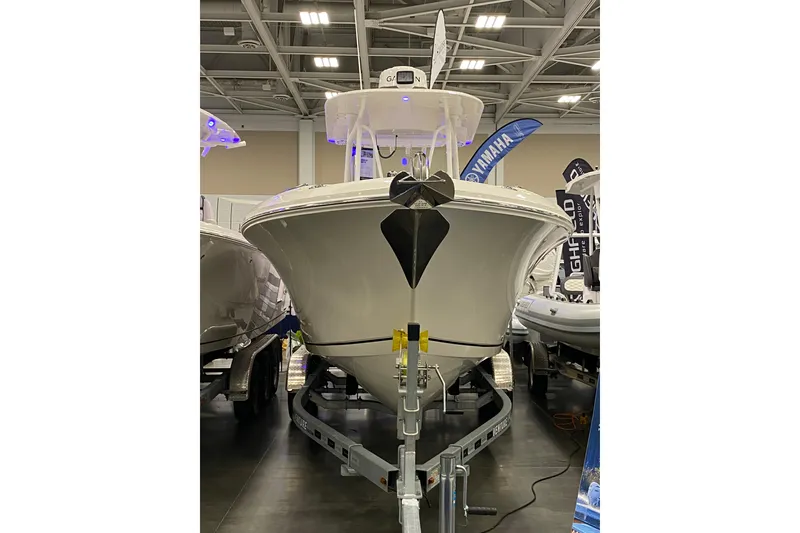 Slide: The Image of 2024 Sailfish 242 CC boat displayed indoors on a trailer. - 9