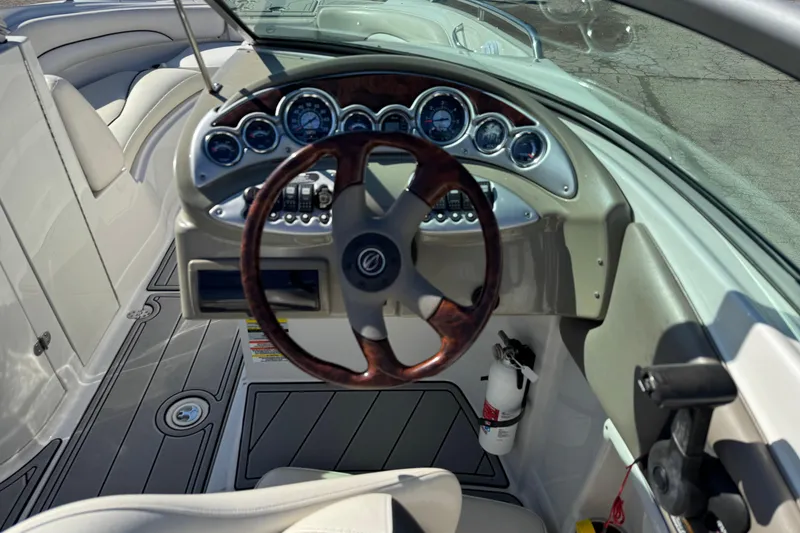 Slide: The Image of 2007 Crownline 240 EX boat dashboard with wood-accented steering wheel and instrument panel. - 16